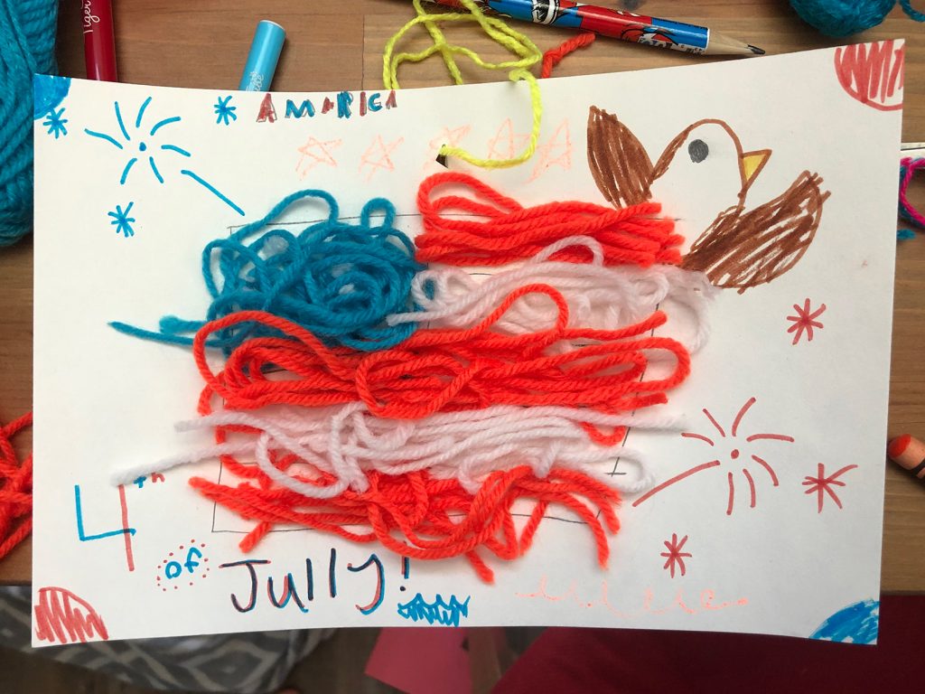Child's drawing of fireworks and a bald eagle bursting out from an American flag made of yard, plus the words "America" and "4th of Jully!"