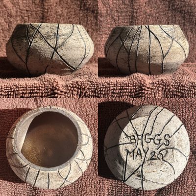 Four photos of the same small ceramic bowl. The first two photos show the vase from the side; lines approximately one-sixteenths of an inch in width were carved vertically down the sides at various angles, intersecting randomly to create rough triangular shapes in the clay. A black glaze was applied and wiped off before firing, leaving dark streaks on the surface and within the lines. A third photo shows the vase from above; the glaze was applied to the interior but not wiped off and is revealed to be a dark metallic gold. The last photo shows the bowl from the bottom, where the lines from the sides continue underneath to form the words, “Baggs” and “May 26.”