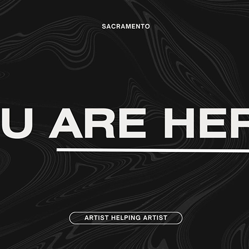 Excerpt of a website banner image featuring white, all-caps, sans-serif text on a black background, the black textured with barely-perceptible, dark-gray lines of distorted wood grain. In small text at the top of the image is the word “SACRAMENTO.” At the bottom, text of the same size but surrounded by a rectangle with rounded sides reads, “ARTIST HELPING ARTIST.” Large text in the middle of the banner has been cut off on each side, leaving “[ … ]U ARE HE[ … ]; the “ARE HE” portion is underlined.